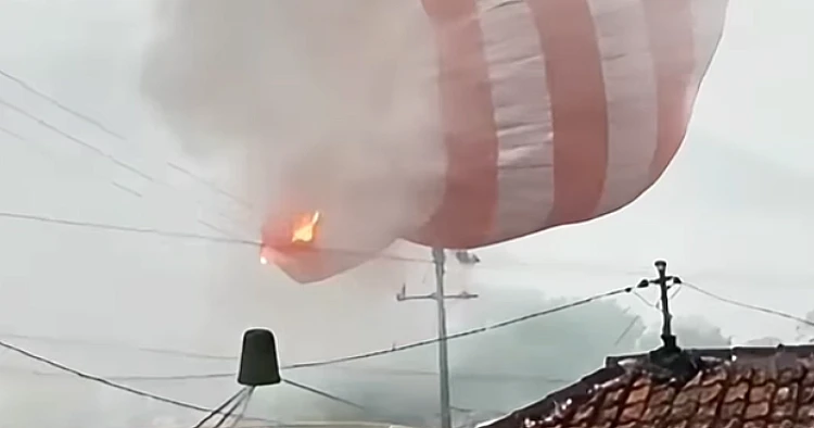 Tangkap layar video yang menampilkan sebuah balon udara tersangkut di tiang listrik di Malang