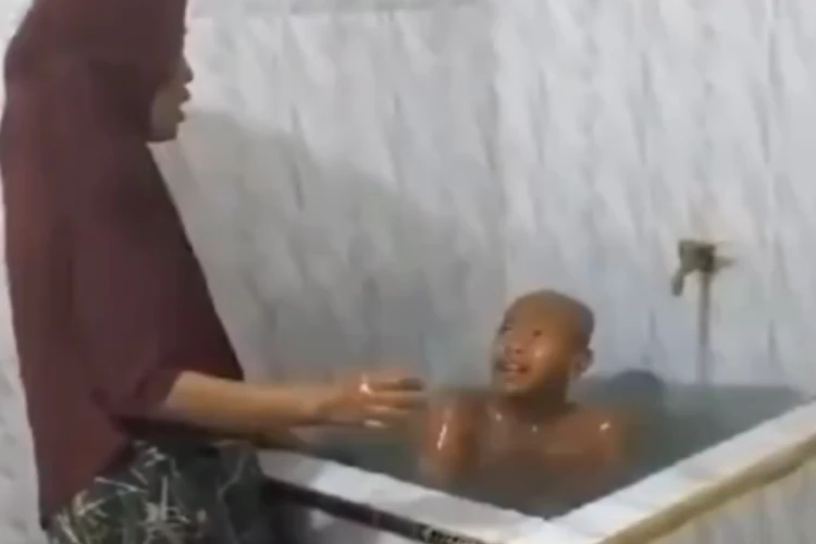 Tangkap layar video viral yang memperlihatkan nenek merawat cucunya setelah diduga habis disiram air cabai oleh istri pimpinan pondok pesantren di Aceh