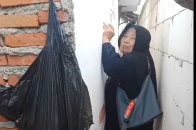 Tangkap layar video ibu-ibu yang mencoba melewati jalan yang aksesnya ditembok salah satu saudara yang cekcok di Kecamatan Singosari Malang