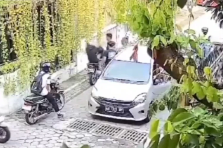 Tangkap layar video yang merekam seorang pengemudi mobil pukul  pengendara motor di salah satu tikungan di Jogja