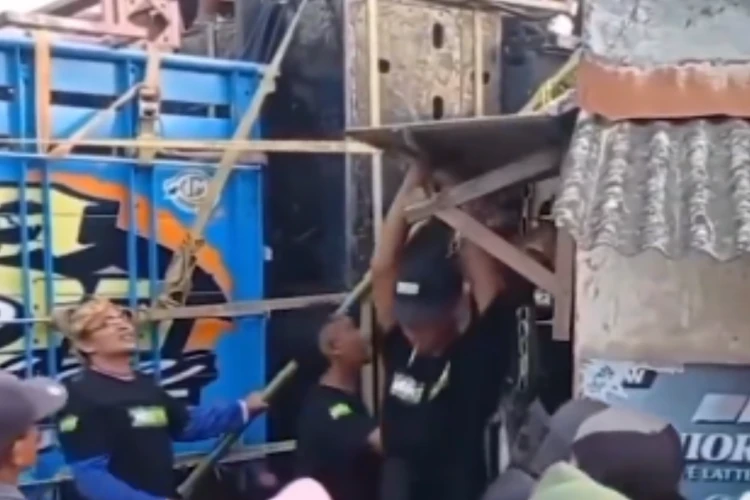 Tangkap layar video yang memperlihatkan para kru sound horeg terpaksa merusak bangunan usaha milik warga di Jember agar mobil sound bisa lewat