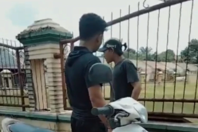 Tangkap layar video dua pria yang diduga hendak mencuri pintu besi di Pekanbaru ketahuan warga setempat ketika hendak beraksi