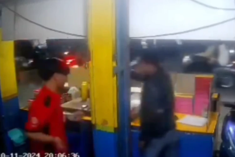 Tangkap layar video CCTV ketika seorang pria berjaket hitam melakukan penganiayaan kepada penjual martabak di Bandung Jawa Barat