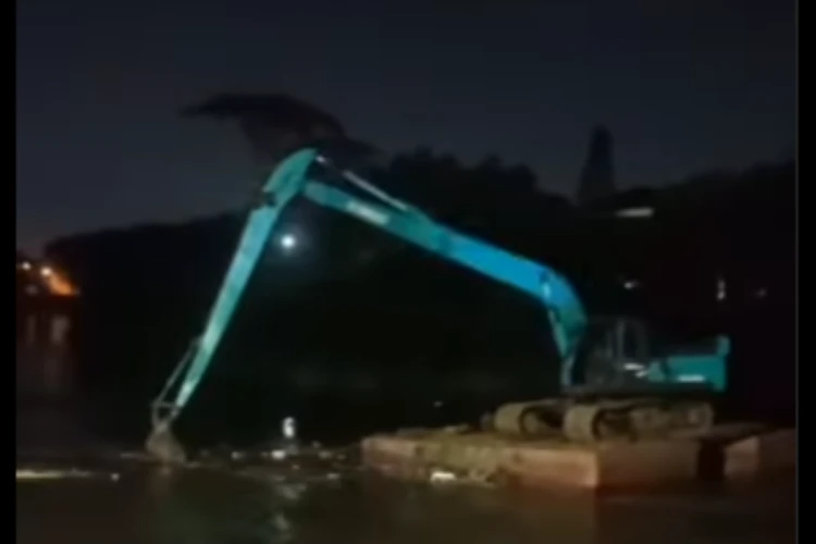 Tangkap layar video yang menampilkan momen alat berat excavator hanyut di kali Bekasi