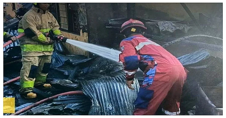 Petugas Damkarmat Makassar sedang melakukan proses pendinginan setelah berhasil memadamkan kebakaran di wilayah padat penduduk Kampung Pa’celang.