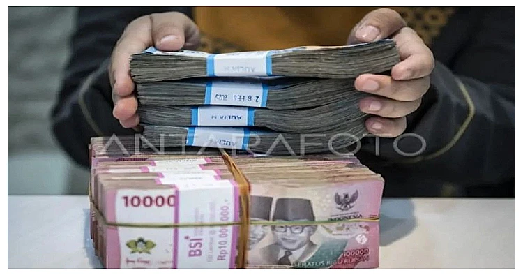 Ilustrasi – Seorang petugas tengah menghitung lembaran rupiah di lokasi penukaran uang.