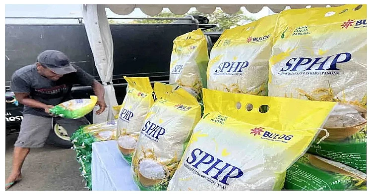 Seseorang menyusun karungan beras SPHP kemasan 5 kg dalam kegiatan gerakan pangan murah yang dilaksanakan di Gudang Bulog Jakarta.