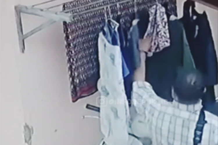 Tangkap layar video CCTV yang memperlihatkan momen pria paruh baya memasukkan bawang merah ke pakaian dalam yang dijemur di Depok