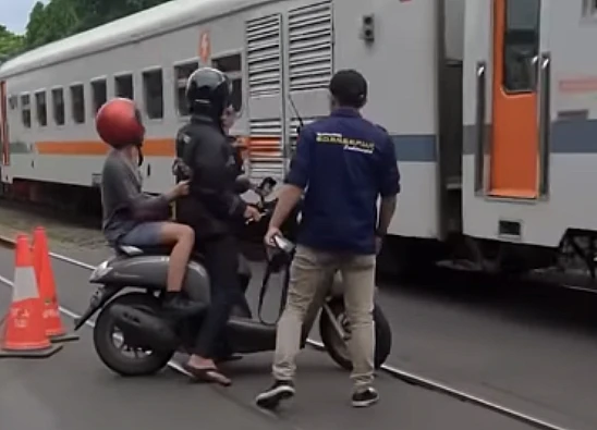 Tangkap layar video yang menampilkan momen pengendara motor di Bandung marah-marah padahal ditolong karena hampir tertabrak kereta api