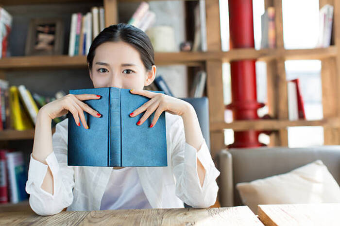 <p>Ket Foto: Ilustrasi foto seseorang yang bersembunyi di bali buku (Foto/Pixabay/Introvert)</p>
