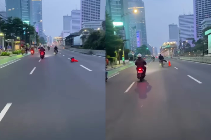 <p>Ket Foto: Seorang pengendara motor tengah menjatuhkan traffic cone (Foto/Instagram/@walkingncofee)</p>
