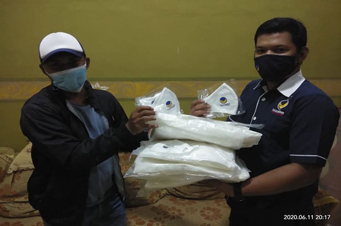 <p>Ket Foto: Penyerahan bantuan APD Nasdem Parimo diwakili Wakil Ketua Digisiber, Muhammad Rifki (kanan).</p>

