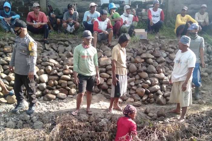 <p>(Foto: Warga Purwosari melakukan pembersihan saluran air yang tertutup oleh meterial bebatuan dan limbah kayu, Mawan) </p>
